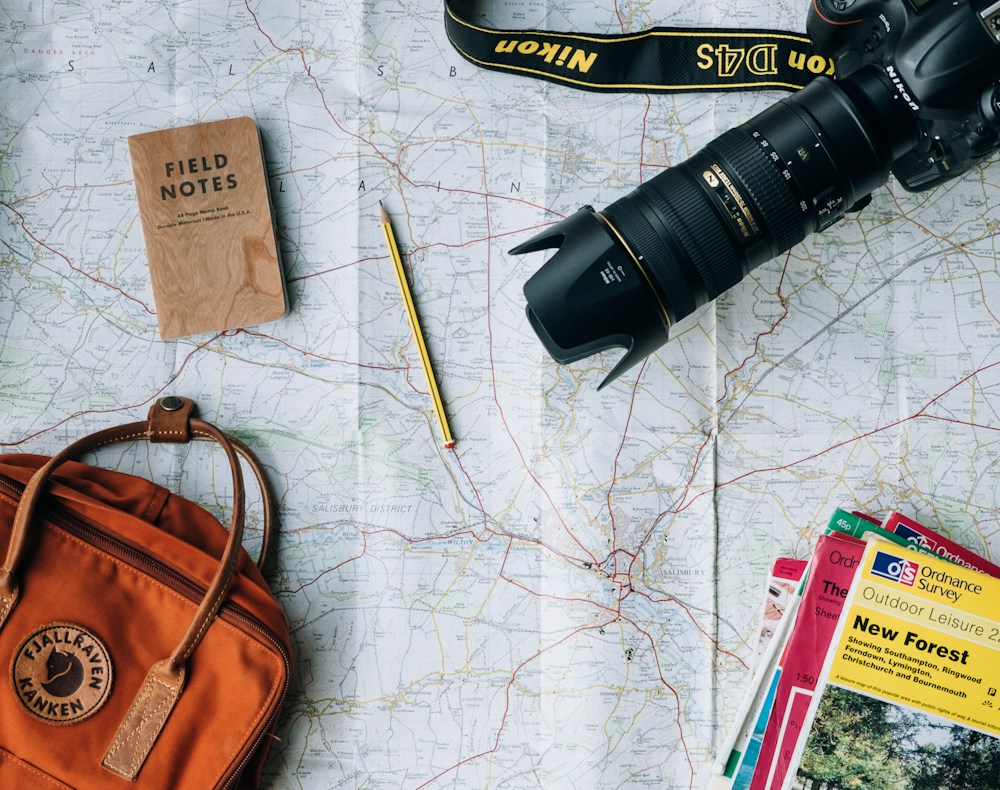 Travel maps, a camera and essentials ready for a journey